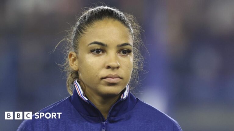 Delphine Cascarino: France forward joins London City Lionesses Delphine Cascarino watches on, wearing a tracksuit top, before a France international