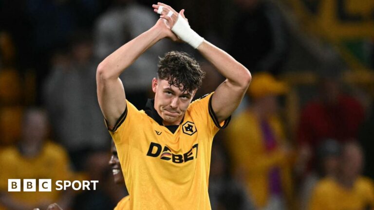 Jorgen Strand Larsen: Wolves reject Leeds offer for Norway striker Jorgen Strand Larsen applauding with arms raised above his head while wearing Wolves match kit, with bandaging on his left wrist