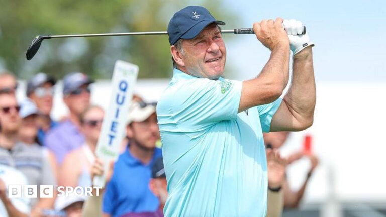 Sir Nick Faldo returns home after open-heart surgery Sir Nick Faldo wearing a light blue t-shirt and a dark blue baseball cap holds a golf club over his shoulder