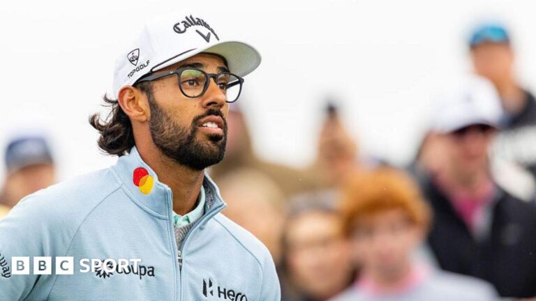 AT&T Pebble Beach Pro-Am: Birdie run puts Akshay Bhatia ahead Akshay Bhatia looks on at the ninth tee. He has a black beard and is wearing black-rimmed glasses, a white cap and a light blue zip-up top. People in the crowd can be seen behind him.
