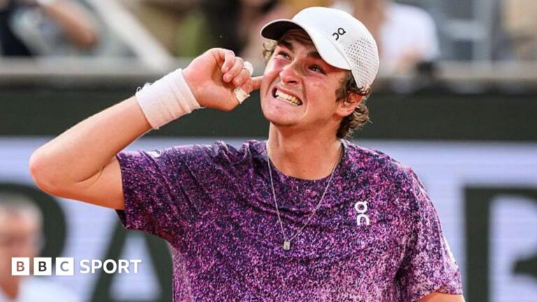Joao Fonseca: Why French Open win over Novak Djokovic marks arrival of 19-year-old Joao Fonseca, wearing a purple top with white flecks and a white cap, grins and puts his right hand behind his ear to appreciate the support of the crowd