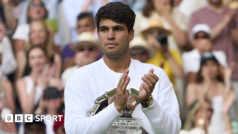 Carlos Alcaraz applauds during the Wimbledon trophy ceremony in 2025