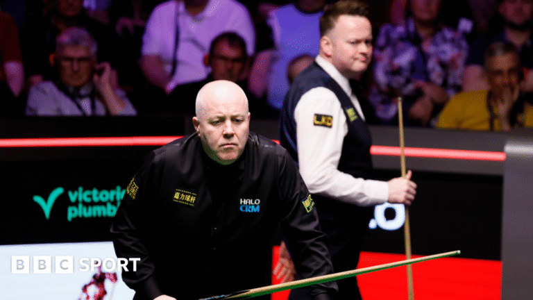 John Higgins eyes a shot