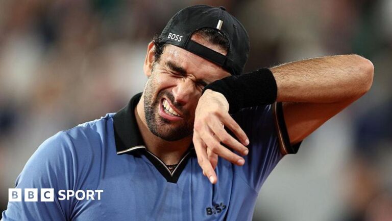 Matteo Berrettini wipes his face with a sweatband on his wrist