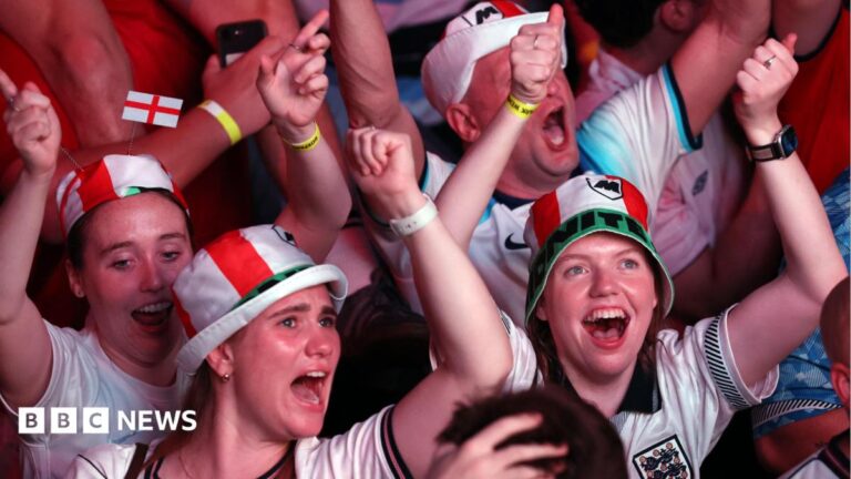 Starmer hints at bank holiday if England win World Cup England fans dressed in red and white hats celebrate with their arms raised during a World Cup match.