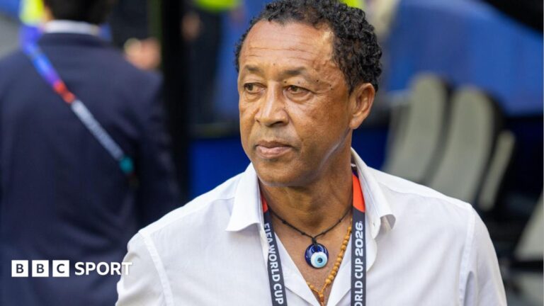 Bubista: Cape Verde coach leaves after World Cup to join Moroccan club RS Berkane Bubista wears a white shirt, two necklaces and a World Cup 2026 lanyard around his neck as he looks to his right while standing in front of a dugout at at a football stadium
