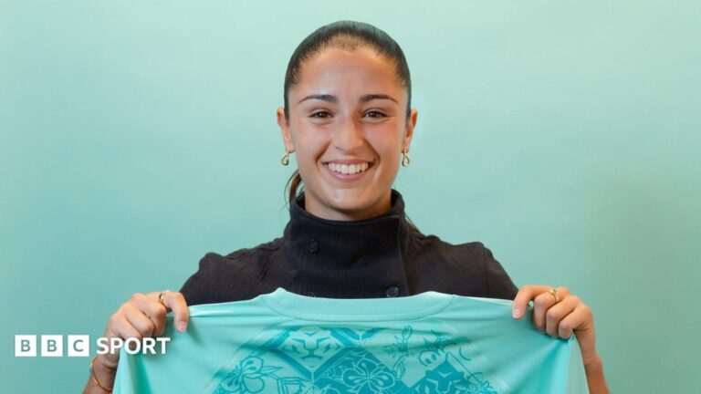 A smiling Jana Fernandez holds a London City shirt