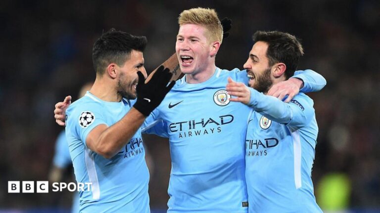 Sergio Aguero, Kevin de Bruyne, and Bernardo Silva celebrate by embracing one another after Manchester City scored a goal in the Champions League